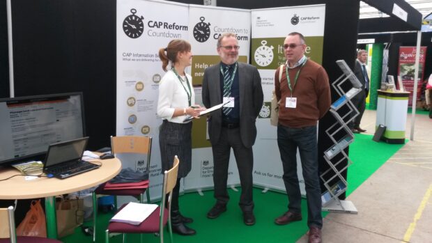 Three people stand at a conference stall for CAP reform