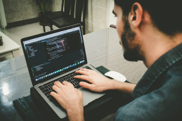 An image of a person on a laptop coding.