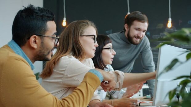 A team of people working together at a computer.